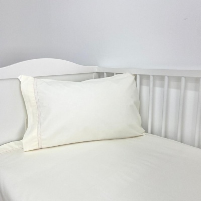 Conjunto de roupa de cama branco num berço branco