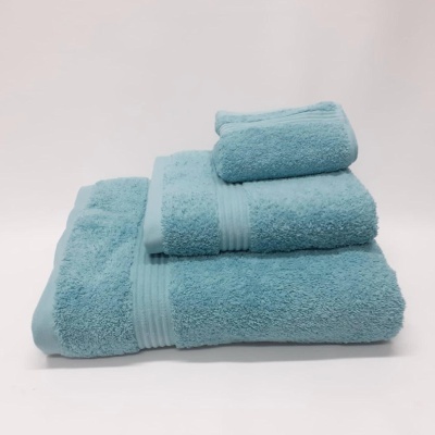 Conjunto de três toalhas azul claro empilhadas em fundo branco.