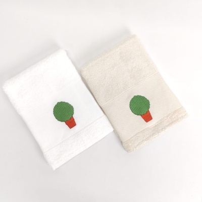 Duas toalhas felpudas, branca e creme, com bordado de vaso de planta