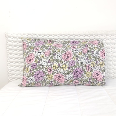 Almofada decorativa floral sobre cama branca