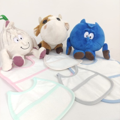 Brinquedos de pelúcia e babetes coloridos sobre mesa branca