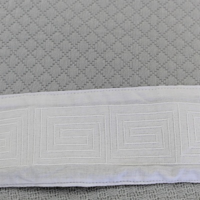 Toalha cinzenta com faixa branca bordada em padrão espiral