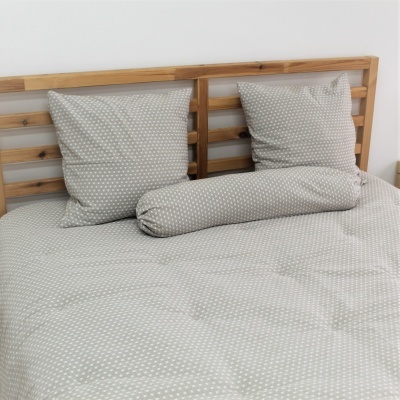 Conjunto de roupa de cama cinza com padrão branco e cabeceira de madeira.