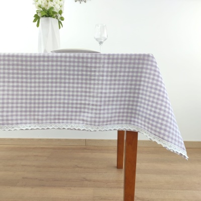 Toalha de mesa lilás xadrez com renda branca numa mesa de madeira clara
