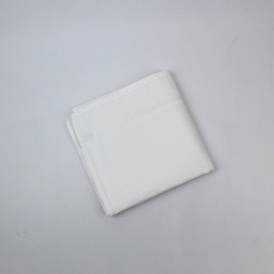 Toalha branca dobrada sobre superfície branca