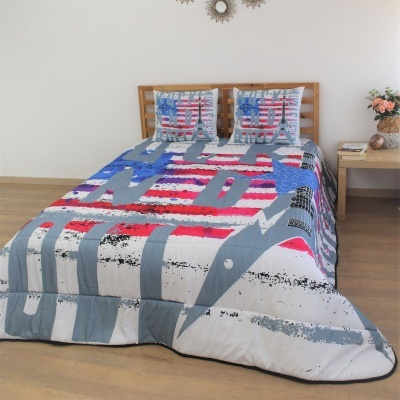 Colcha e almofadas com padrão gráfico colorido em cama de madeira em quarto