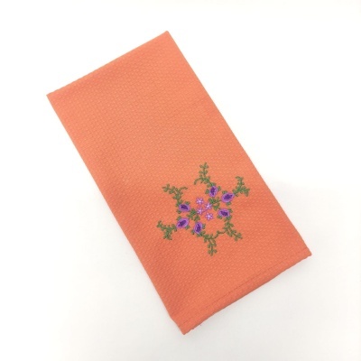 toalha de tecido laranja com bordado floral