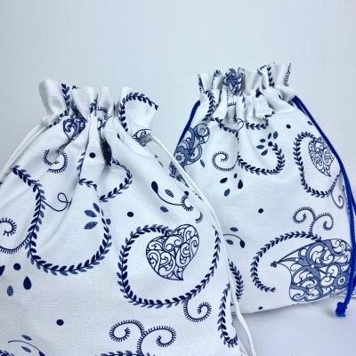 Sacos de tecido branco com padrões azuis e cordões para fechar