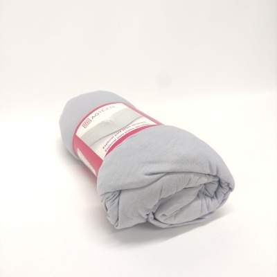 Manta cinzenta clara enrolada com etiqueta vermelha e branca sobre fundo branco