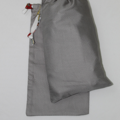 Duas bolsas de tecido cinzento com diferentes texturas e cordões