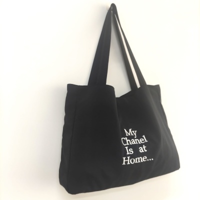 Mala tote preta com texto bordado em branco