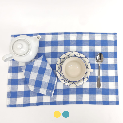 Conjunto de chá em porcelana e têxteis azuis e brancos sobre mesa branca
