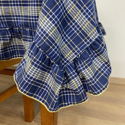 Tecido azul xadrez com volantes sobre mesa de madeira clara