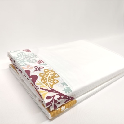 Lençóis brancos com borda colorida dobrados