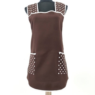 Vestido castanho com padrão de bolinhas brancas nas alças e bolsos