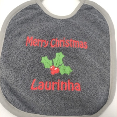 Babete cinzento escuro com texto vermelho Merry Christmas Laurinha e folhas de azevinho bordadas