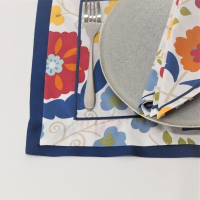 Guardanapo floral, prato cinza e garfo sobre superfície branca