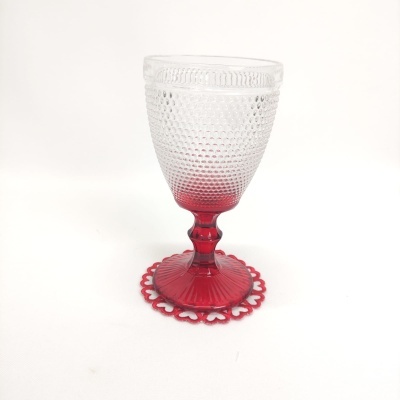 Taça de vidro translúcido com base vermelha e suporte vermelho perfurado