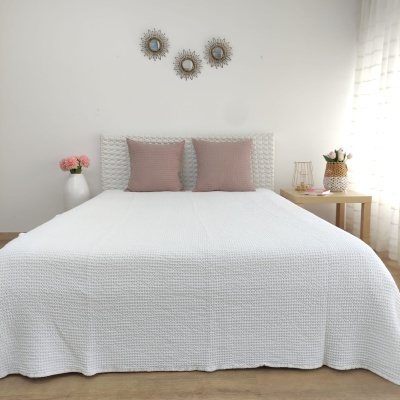 Cama casal branca com almofadas cor-de-rosa e decoração minimalista