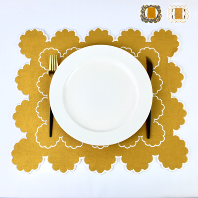 Jogo americano dourado com prato branco, garfo e faca dourados, fundo branco