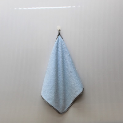 toalha azul claro pendurada numa parede branca