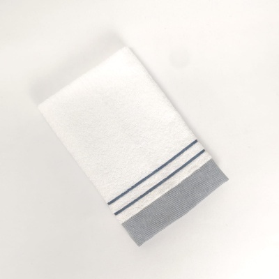 Toalha branca com riscas azuis e faixa cinzenta