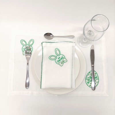 Conjunto de mesa branco com bordados de coelhos verdes, prato branco, talheres e copo
