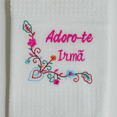 Toalha branca com bordado colorido e texto 'Adoro-te Irmã'.