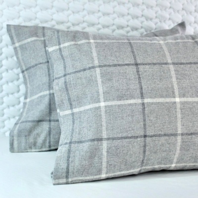 Duas fronhas xadrez cinza e branco sobre fundo branco