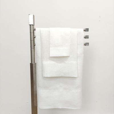 Conjunto de três toalhas brancas penduradas numa barra metálica