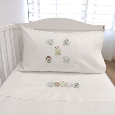 Jogo de cama branco para berço com bordados de animais fofos em tons suaves.