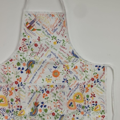 Avental de cozinha branco com padrão colorido de flores e texto manuscrito