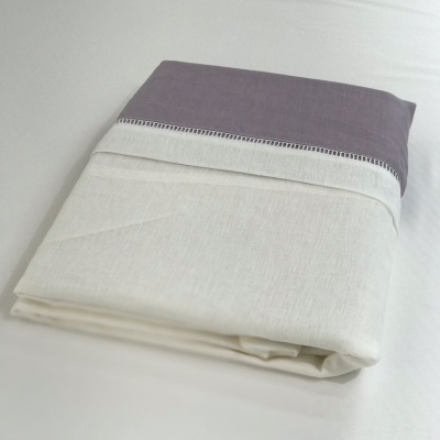 Lençol dobrado branco e lilás sobre superfície branca