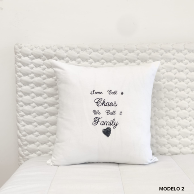 Almofada branca com texto bordado em cama branca e cabeceira acolchoada branca