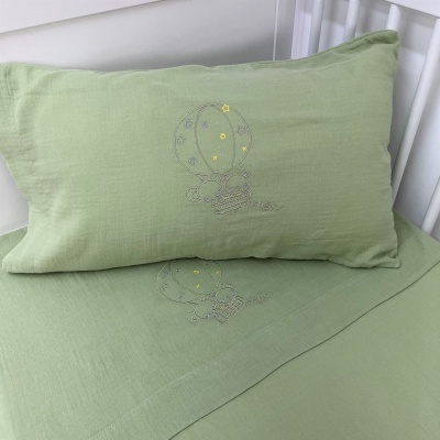 Jogo de cama verde claro com bordado de balão de ar quente em cama branca