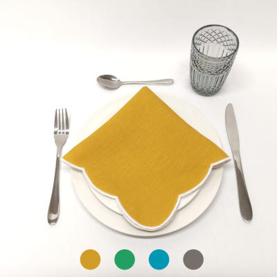 Conjunto de mesa com guardanapo amarelo, prato branco, talheres metálicos e copo de vidro cinza