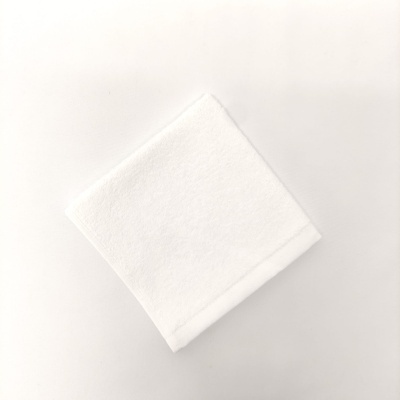 Toalha branca dobrada com faixa decorativa simples
