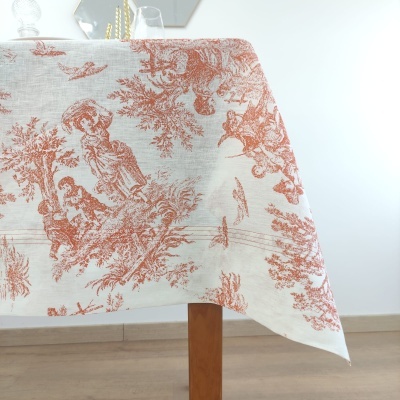 Toalha de mesa creme com padrão vermelho de cenas vintage sobre mesa de madeira