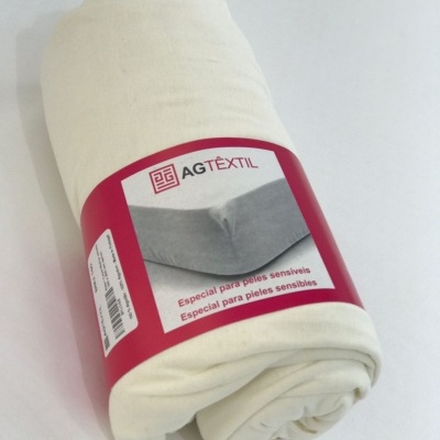 Produto têxtil enrolado com etiqueta AGTÊXTIL e texto especial para peles sensíveis.