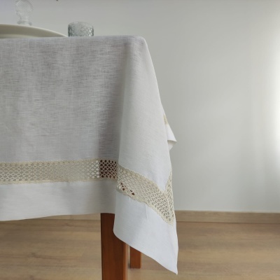 Toalha de mesa branca com barra decorativa em renda bege sobre mesa de madeira