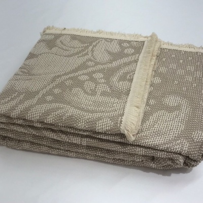 Manta ou cobertor tecido bege com padrão floral e franjas nas bordas