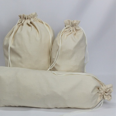 Três sacos de algodão cru com fecho de cordão de diferentes tamanhos.