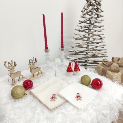 Decoração natalícia com candelabros, renas de madeira, toalhas de natal, bolas decorativas, árvore rústica de ramos e caixas douradas