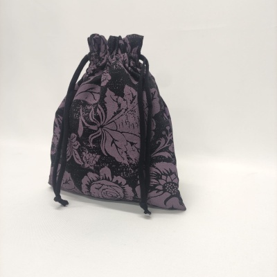 Saco de tecido preto e roxo com padrão floral e fecho de cordão