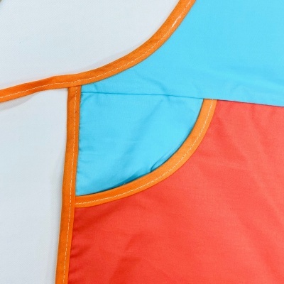 Detalhe de peça têxtil colorida com acabamentos em laranja