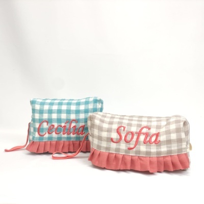 Dois sacos de tecido xadrez com nomes bordados e faixa rosa pregueada na base