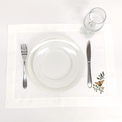 mesa posta com prato branco, talheres metal e copo vidro transparente