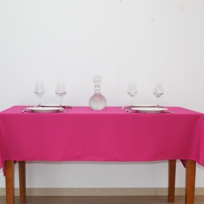 Mesa de madeira com toalha rosa e serviço de mesa simples