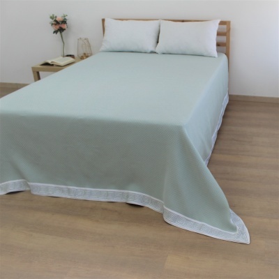 Cama de madeira com lençol verde claro e almofadões brancos
