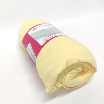 Edredão amarelo claro enrolado com etiqueta branca e rosa sobre fundo branco